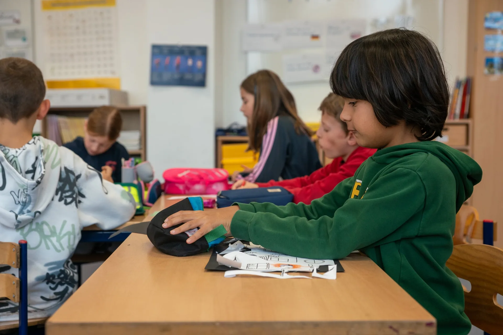 Schülerinnen und Schüler arbeiten konzentriert an Tischen im Klassenraum.